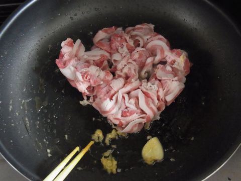 まずフライパンにごま油をひいて、しょうがすりおろしとスライスしたにんにくと豚肉を炒めます。